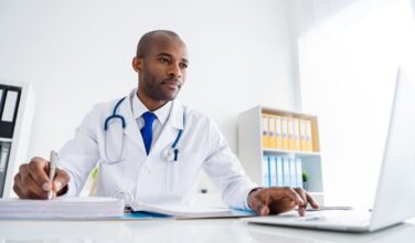 Arts die op een laptop kijkt en iets opschrijft, gezondheidsgegevens EHDS
